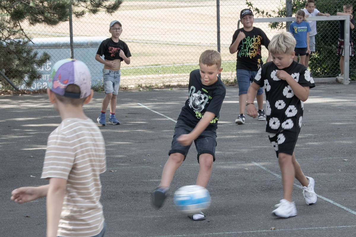 Kinder spielen Fussball auf dem Pausenplatz