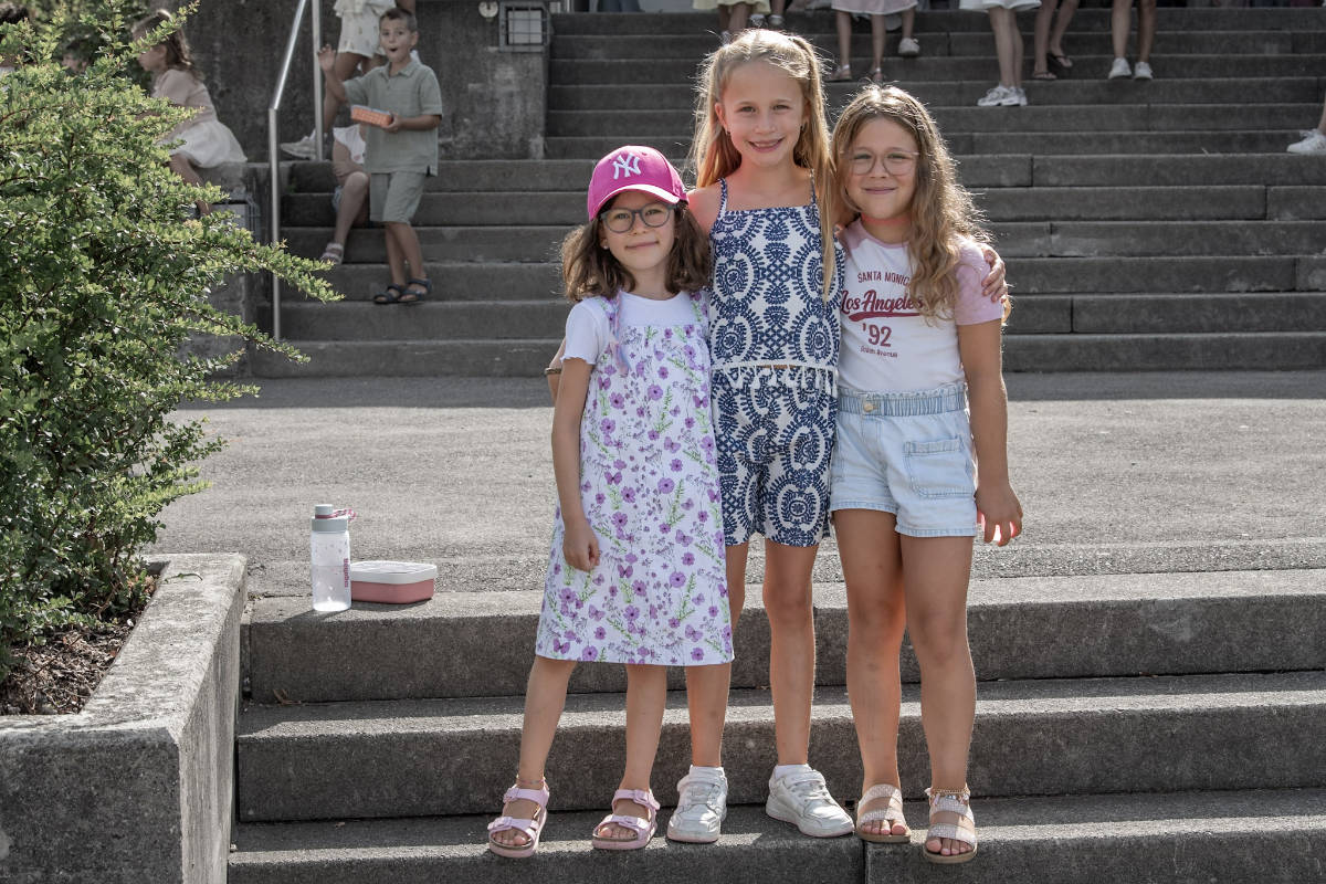 Drei Kinder auf der Treppe vor dem Schulhaus Bannegg