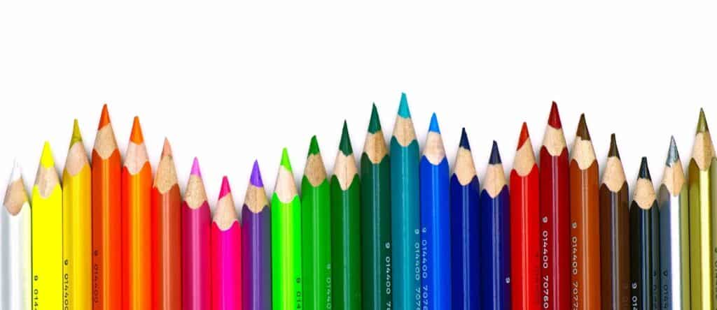 Farbstifte in allen Regenbogenfarben, gespitzt und nebeneinander aufgereiht